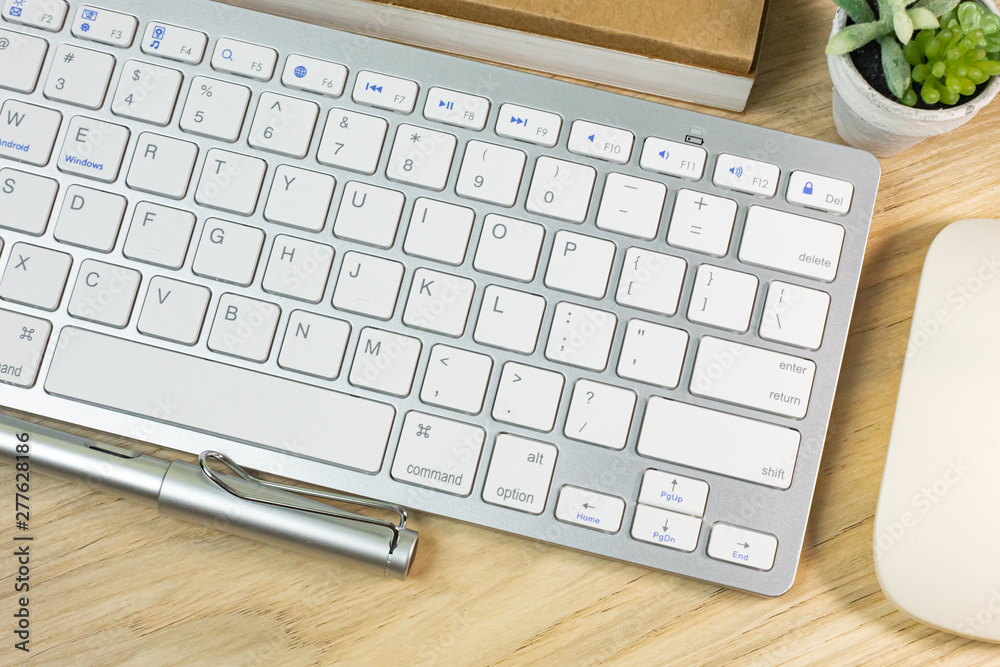 silver keyboard on wood table flat lay image.. silver keyboard on wood table flat lay image..