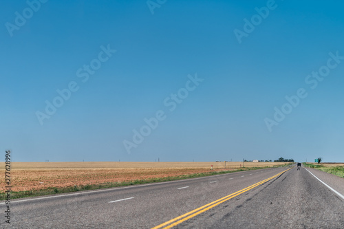 Brownfield  USA Texas countryside rural town historic farm road view from 380 highway with prairie dry grass field and blue sky