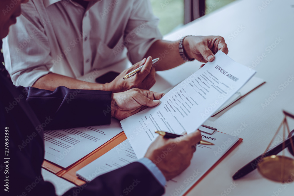 Group of middle age Asian business people and lawyers discussing and sign a contract.