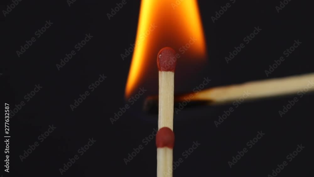 Slow ignition of ignition of two matches close up macro shot captured from the left side on the black background in slow motion at 120 fps. Slow ignition of ignition of two matches close up macro shot captured from the left side on the black background in slow motion at 120 fps.