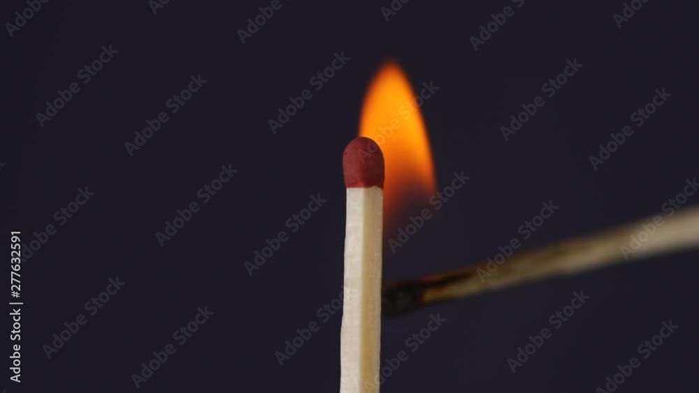 Hand igniting matches close up macro shot captured in front of black background in slow motion at 120 fps. Hand igniting matches close up macro shot captured in front of black background in slow motion at 120 fps.