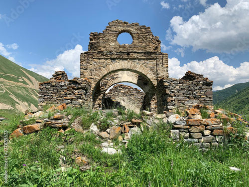 The ruins of the old church of the Assumption in the ancient village of Lisri in the Mamison gorge in the summer. Russia, North Ossetia - Alania photo