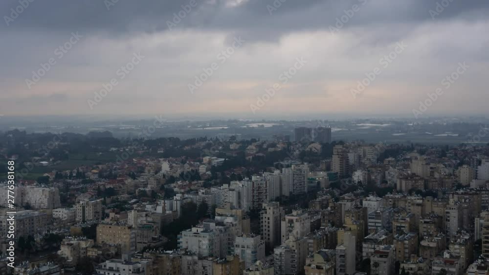 Aerial Time Lapse of a residential neighborhood in a city during a stormy cloudy sunrise. Taken in Netanya, Center District, Israel. Aerial Time Lapse of a residential neighborhood in a city during a stormy cloudy sunrise. Taken in Netanya, Center District, Israel.
