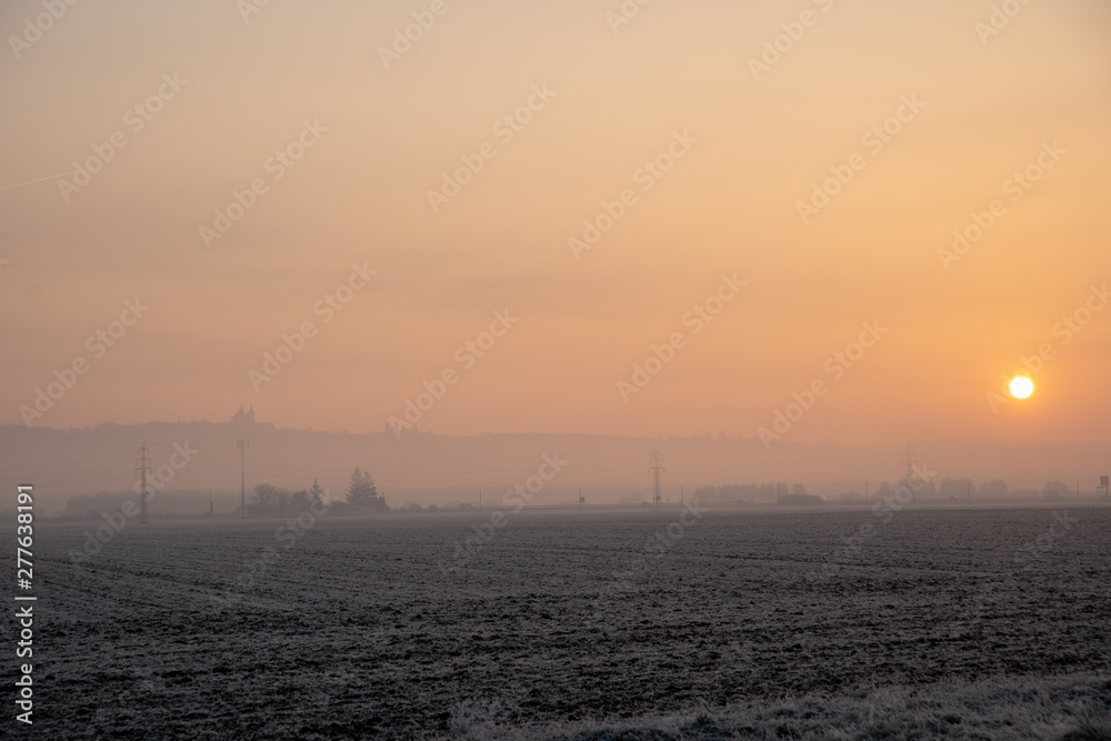 Fototapeta premium frosty autumn morning at sunrise. the road leads from nature to the city. way to work