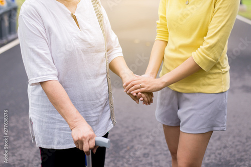 Hand of asian woman holding one's hands elderly while walking at outdoor,Ederly taking care concept