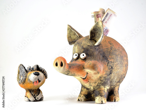 Clay figurine of a dog with his tongue sticking out and piggy Bank.