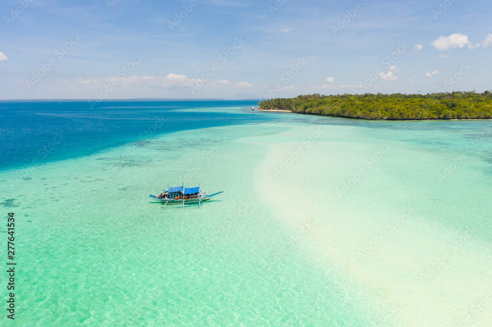 Obraz premium Mansalangan sandbar, Balabac, Palawan, Philippines. Tropical islands with turquoise lagoons, view from above. Boat and tourists in shallow water.