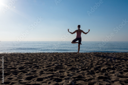 Lonely person practice yoga on the beach by sea shore on a sunny day