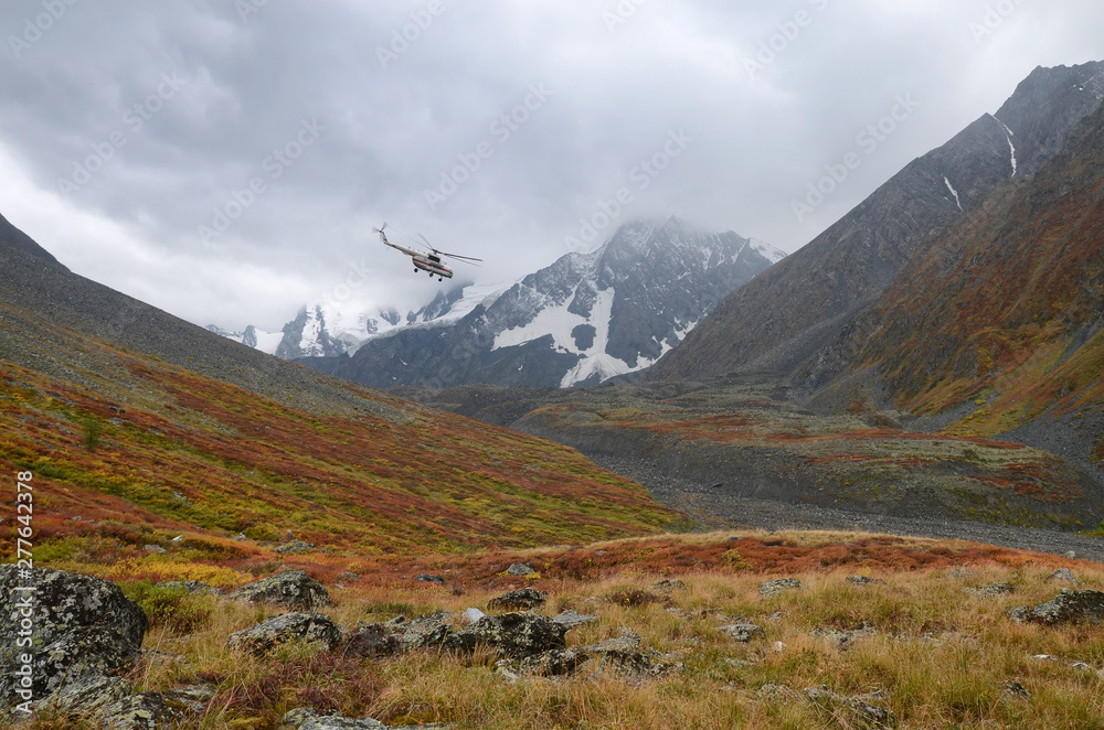 Rescue helicopter over mountains. Altai Republic, Siberia, Russia.