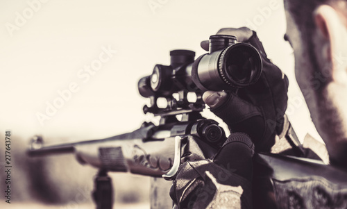 Hunter man. Hunting period. Close up. Hunter with hunting gun and hunting form to hunt. Hunter is aiming. The man is on the hunt. Hunt hunting rifle. Black and white