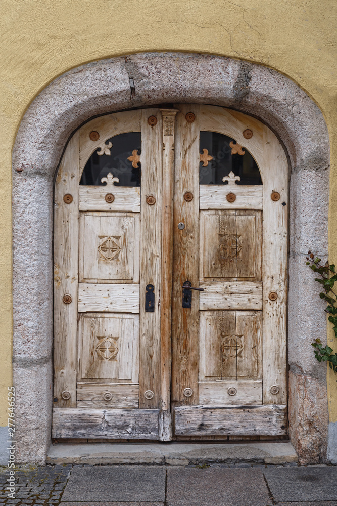 Old wooden door with wooden ornaments in the historic part of the German town of Fussen