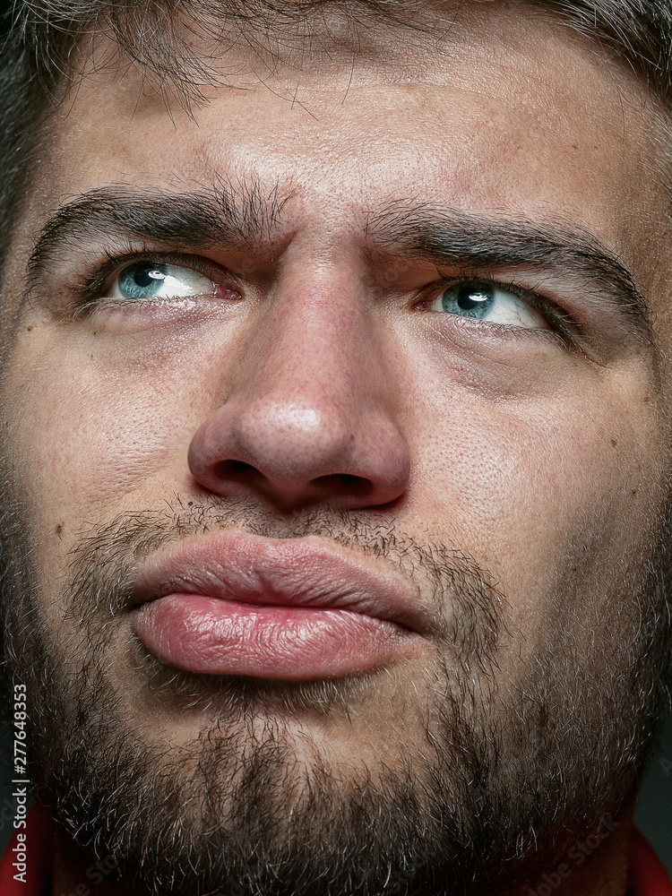 Obraz premium Close up portrait of young and emotional caucasian man. Highly detail photoshot of male model with well-kept skin and bright facial expression. Concept of human emotions. Thinking angry.