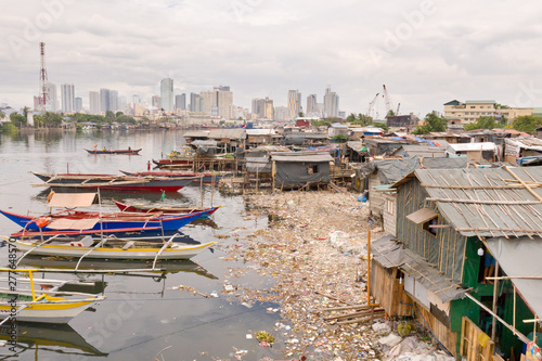 Wallpaper Mural Manila slums on the background of a big city. Houses and boats of the poor inhabitants of Manila. Dwelling poor in the Philippines. Torontodigital.ca