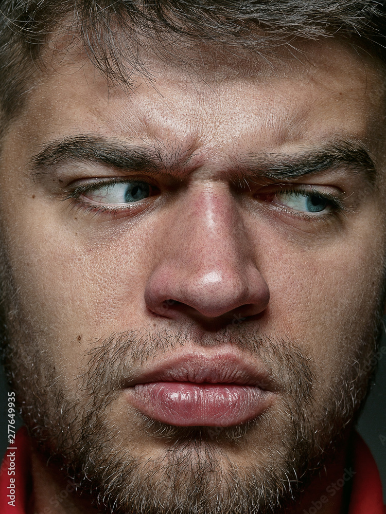 Close up portrait of young and emotional caucasian man. Highly detail photoshot of male model with well-kept skin and bright facial expression. Concept of human emotions. Angry, agressive. Close up portrait of young and emotional caucasian man. Highly detail photoshot of male model with well-kept skin and bright facial expression. Concept of human emotions. Angry, agressive.