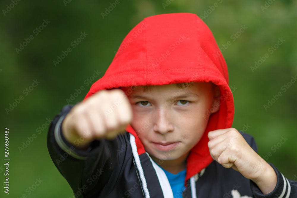 a boy in a black hoodie with a red hood ,shot on a cloudy summer day a boy in a black hoodie with a red hood ,shot on a cloudy summer day