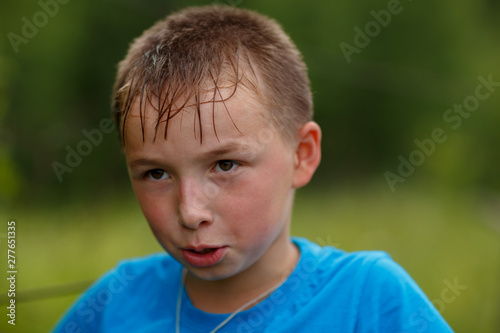 a boy in a blue t-shirt ,shot on a cloudy summer day