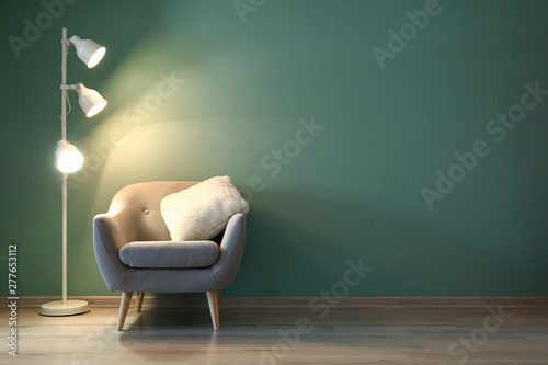 Interior of modern room with armchair and lamp in evening