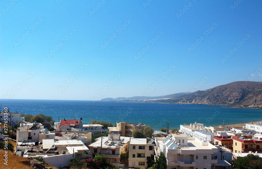 A small town on the coast. City on the beach on the island of Crete. Near the city mountains. Beautiful sea view from the side.