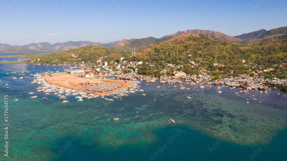 Fototapeta premium Berth with boats in the town of Coron. Palawan. Philippines.Coron Cityscape with Pier and Sulu Sea.City with a pier by the sea aerial view