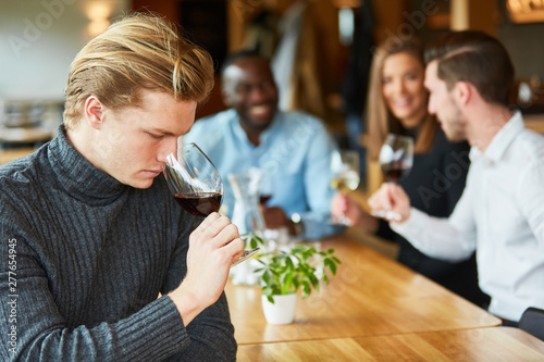 Young man at a wine tasting with red wine