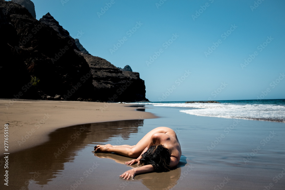 young lonely nude woman laying crouched on pristine beach as a metaphor for  loneliness depression and summertime sadness in a poetic evocative way  Photos | Adobe Stock