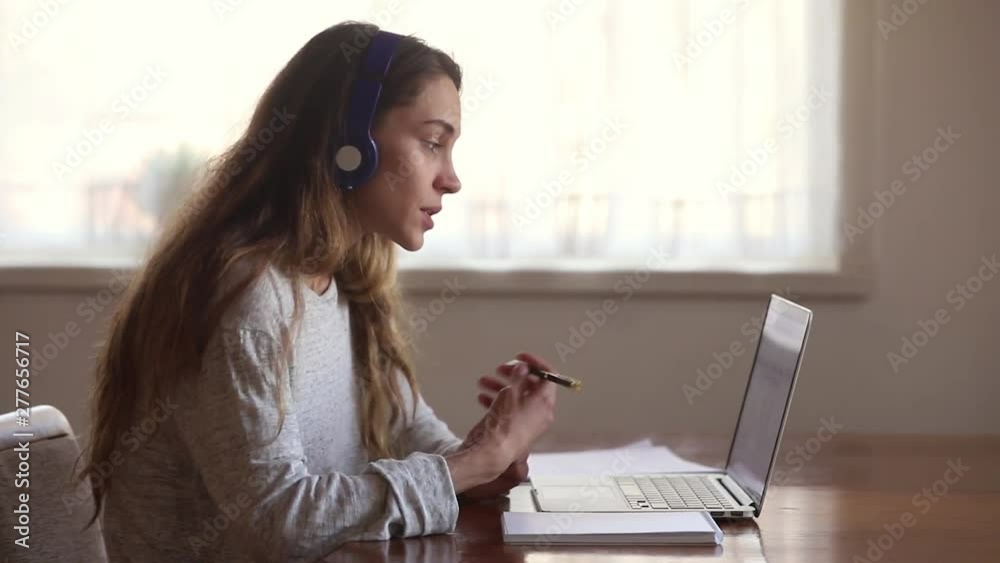 Serious girl student wear headphone study online with internet teacher Serious girl student wear headphone study online with internet teacher
