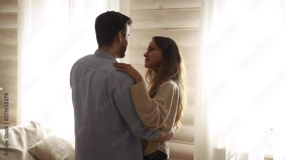Happy romantic young couple enjoy slow dance in living room Happy romantic young couple enjoy slow dance in living room