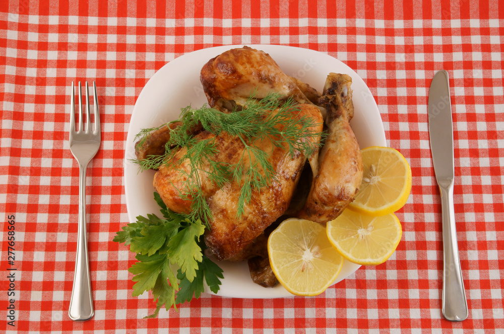 Grilled chicken in white plate on red tablecloth Grilled chicken in white plate on red tablecloth