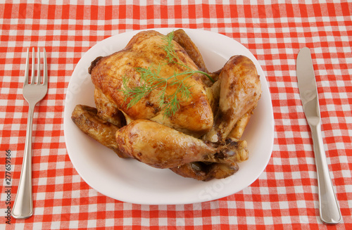 Grilled chicken in white plate on tablecloth