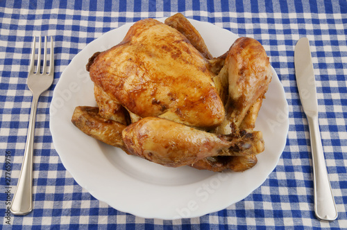 Grilled chicken in white plate on blue tablecloth