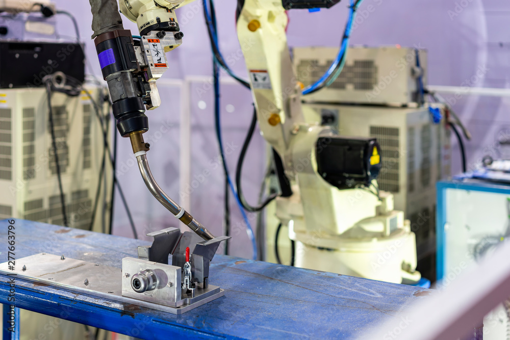 close up workpieces setting on jig fixture with manual quick clamp and torch of electric mig robot welding process at factory close up workpieces setting on jig fixture with manual quick clamp and torch of electric mig robot welding process at factory