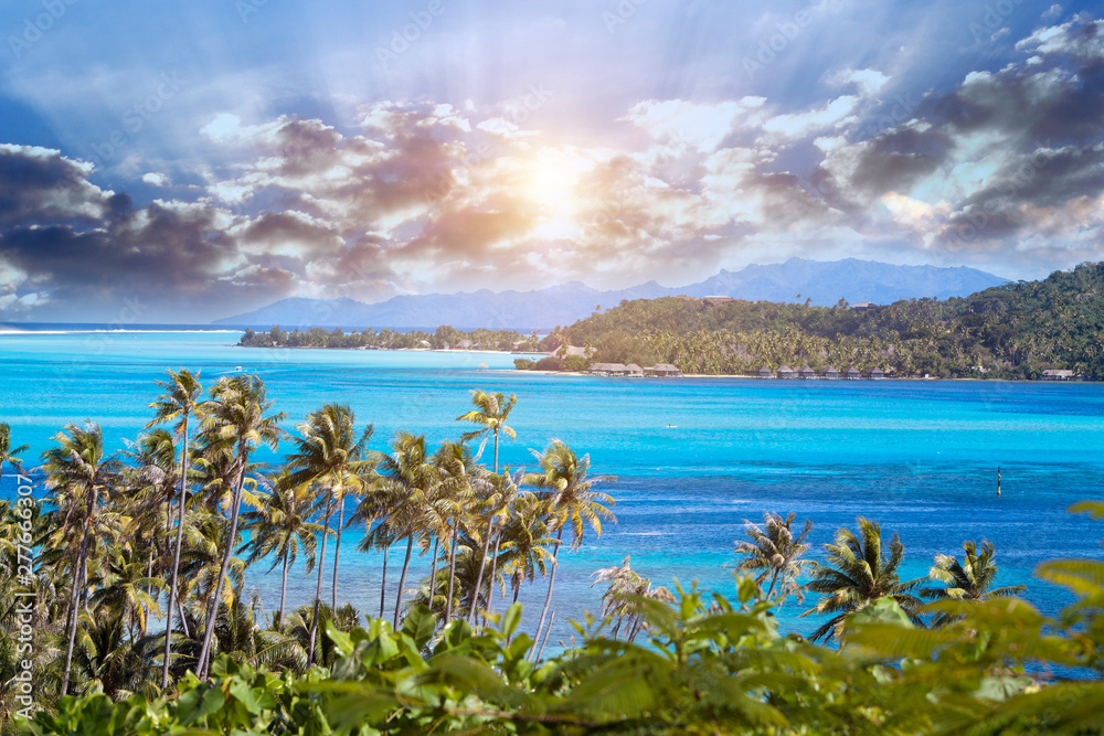 Blue lagoon of the Bora Bora island, Polynesia. Top view on palm trees and the sea..