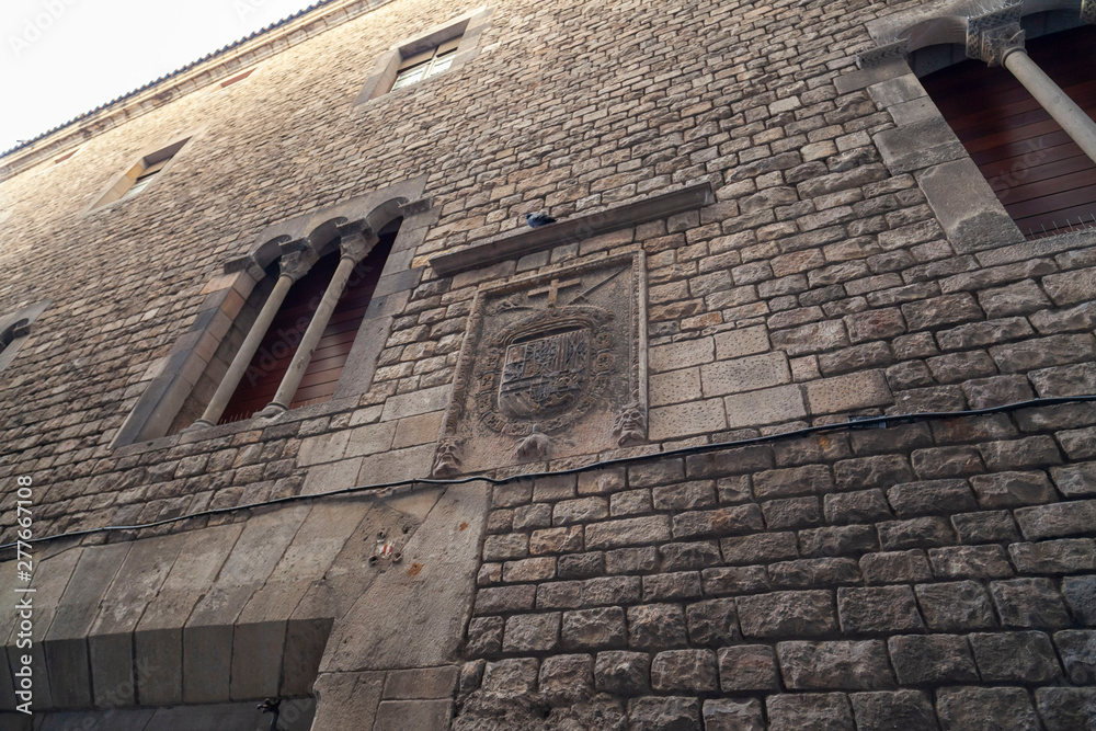 Barcelona, Spain. Historic building Palace, Palau Reial Major and Inquisition shield in wall stone, gothic quarter. Barcelona, Spain. Historic building Palace, Palau Reial Major and Inquisition shield in wall stone, gothic quarter.