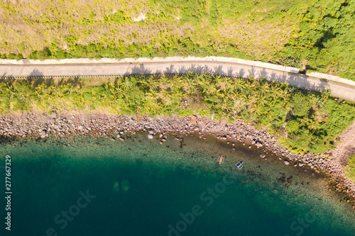 Concrete road along the sea shore, view from above. Stony coast with a blue bay, Philippines.