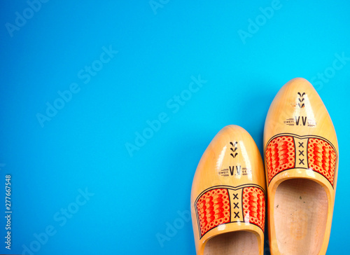 Принти на полотні Traditional dutch wooden clogs isolated on blue background with copy space for y