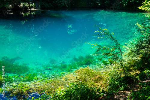 Germany, Blue pot called blautopf in village blaubeuren in swabian jura nature landscape, a deep blue natural source of fresh water inside green forest photo