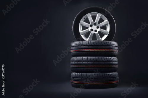 New tires pile on a dark background. Tire fitting background. Copy space. photo