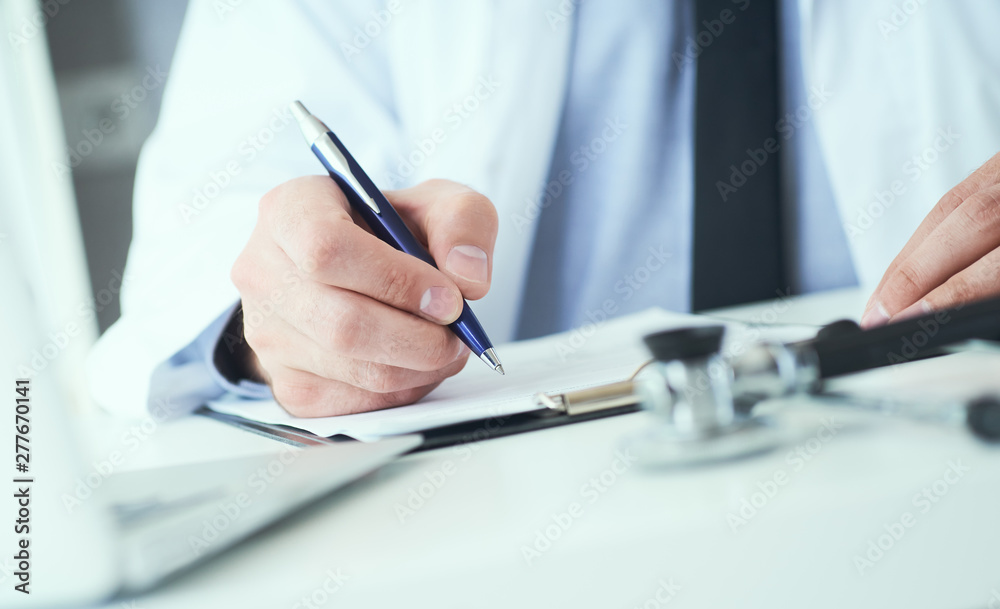 Fototapeta premium Mid section of male doctor writes prescription to patient at worktable. Panacea and life save, prescribing treatment.