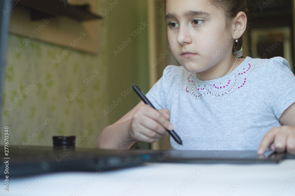 child draws on a graphic tablet