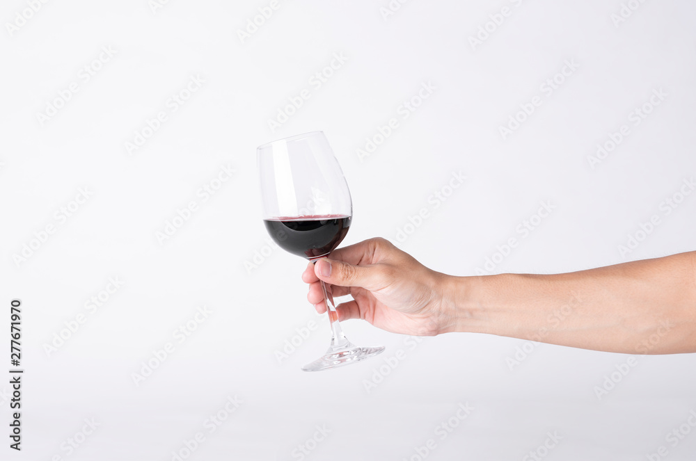 Man hand holding a wine glass on a gray background. Man hand holding a wine glass on a gray background.