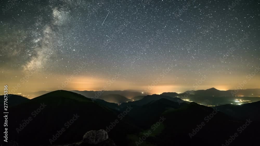 Day to night, Sunset to starry night in mountains Time lapse with milky way galaxy stars moving over countryside traffic