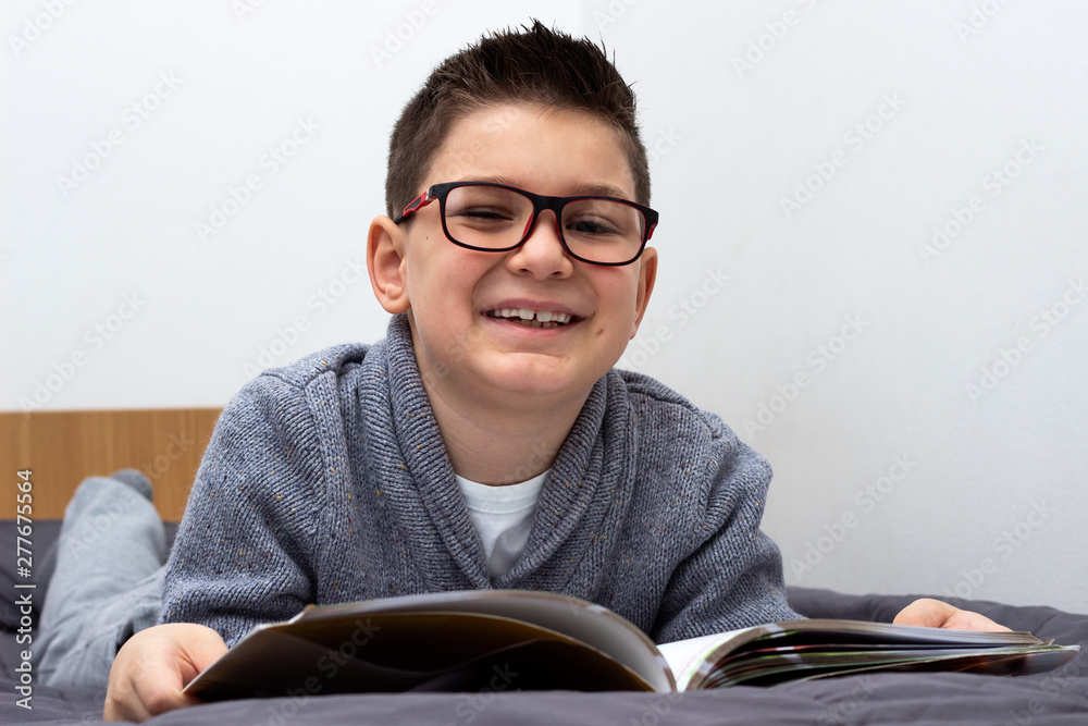 Young boy lying and reading books, Boy studying homework - obrazy, fototapety, plakaty 