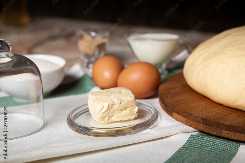 Bakery ingredients. On the table are butter, eggs, milk, yeast, sugar Bakery ingredients. On the table are butter, eggs, milk, yeast, sugar
