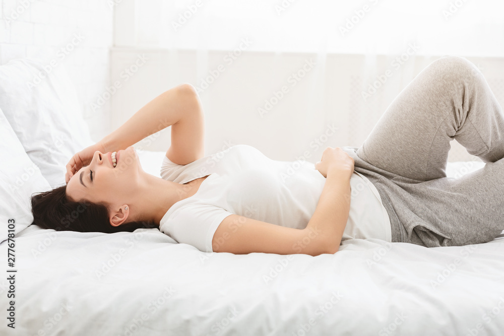 Laughing woman lying in bed early in morning Laughing woman lying in bed early in morning