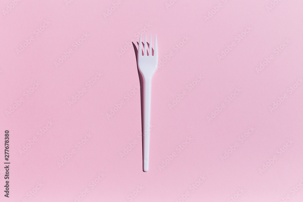 pink background with plastic fork and hard shadows pink background with plastic fork and hard shadows