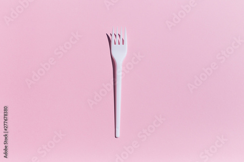 pink background with plastic fork and hard shadows