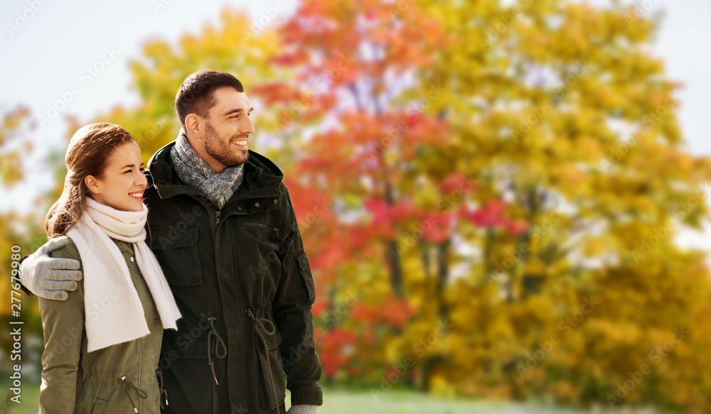 love, relationship and people concept - smiling couple hugging over autumn park background
