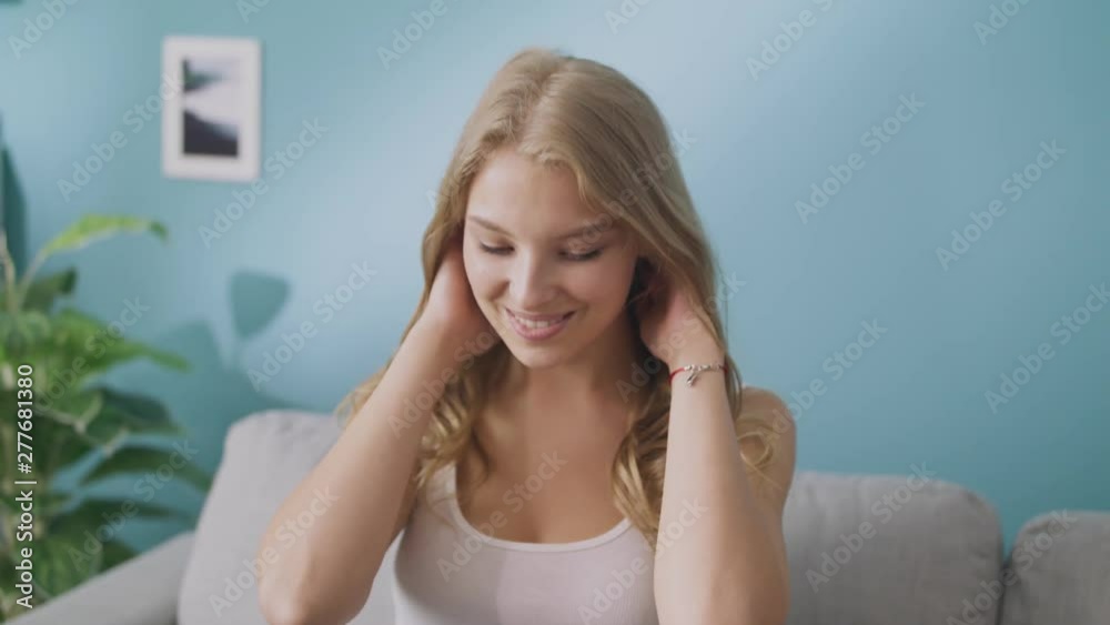 Portrait of happy young lady looking at camera and smiling in cozy living room Portrait of happy young lady looking at camera and smiling in cozy living room
