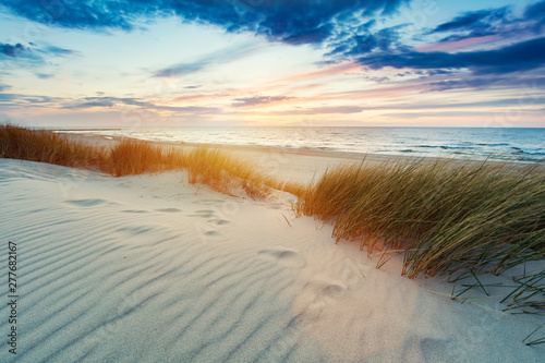 Grassy dunes and the Baltic sea at sunset photo