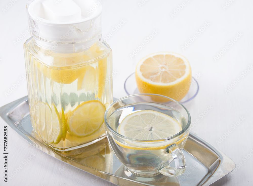 Lemon water in a glass jug and in a glass cup Lemon water in a glass jug and in a glass cup